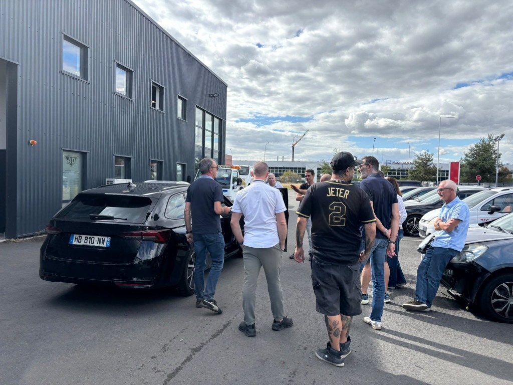 Échanges techniques du groupe devant un véhicule à expertiser